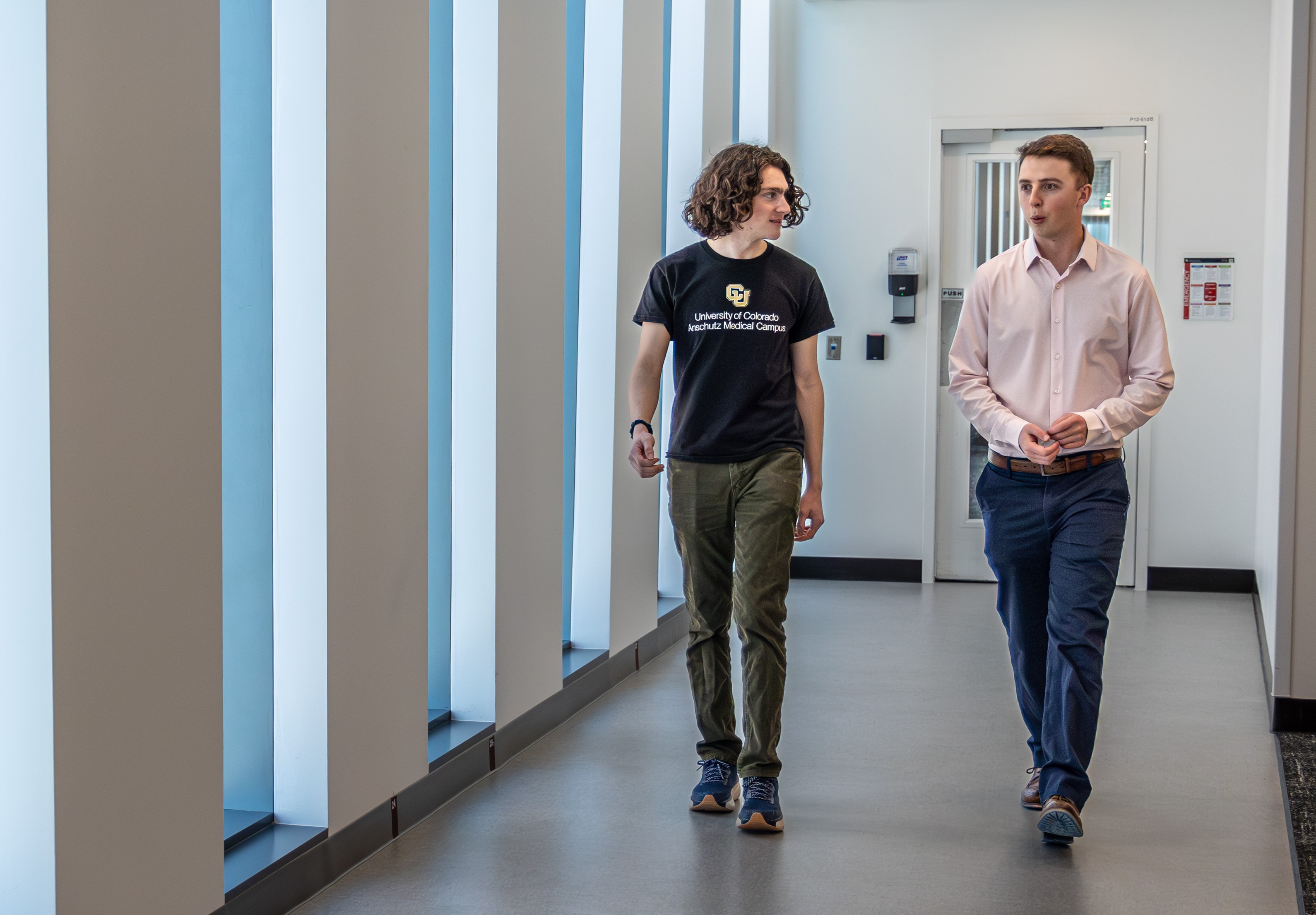 two people walking down hallway